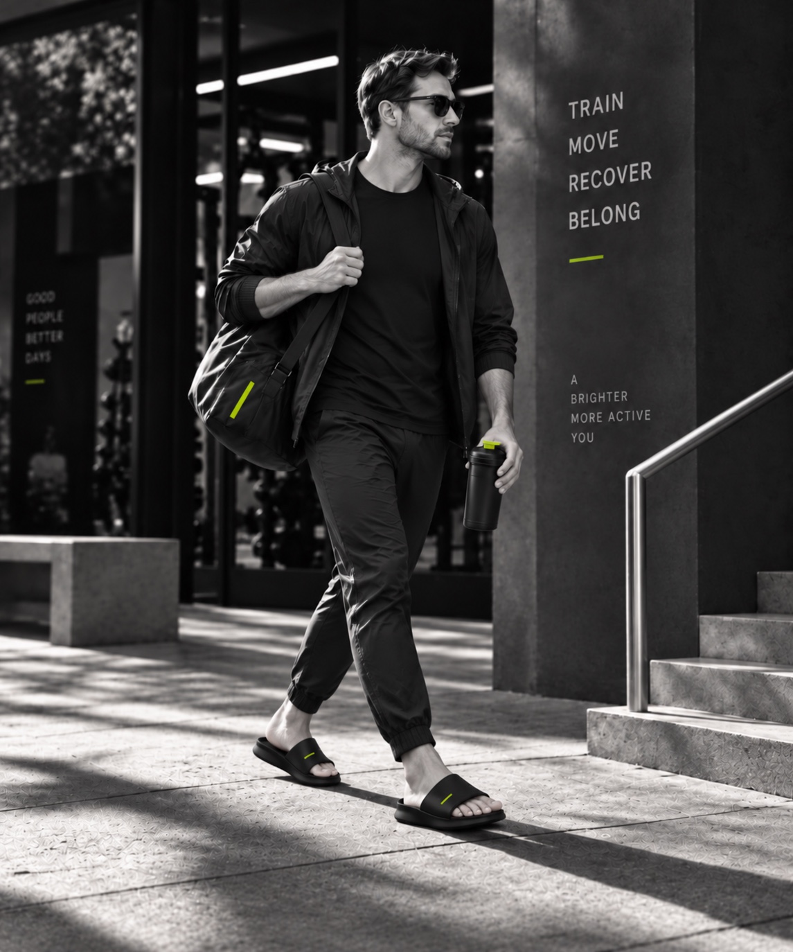 Man in athletic clothing wearing black slides outside a gym